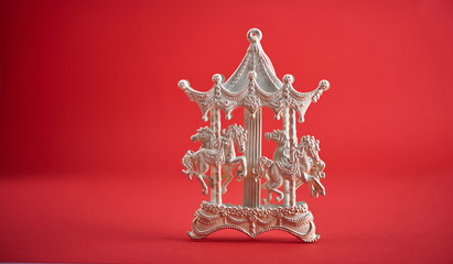 Christmas background. Cristmas decoration toy carousel over red background.