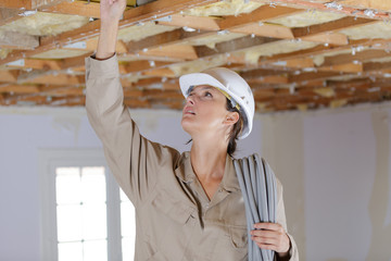female electrician wiring inside ceiling © auremar