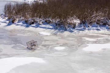 crab trap frozen in ice on a southern maryland creek along the chesapeake bay in southern maryland calvert county - obrazy, fototapety, plakaty