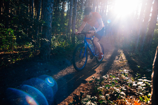 Extreme Biker Riding His Bicycle Downhill While Wearing No Safety Equipment While Hitting The Brakes Hard On A Dirt Trail.