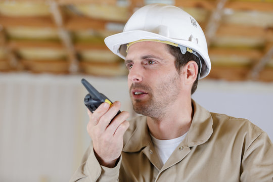 male worker in helmet with walkie talkie in shipping stock