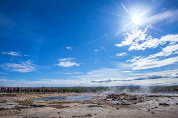 Geysir Strokkur calm before the explosion and the sun in the background. Iceland