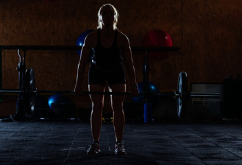 Girl training in the gym, low key, dark image