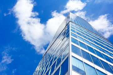 Fototapeta na wymiar High-rise glass building on a background of blue sky and clouds.