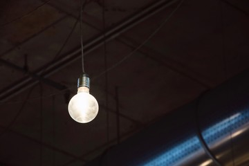 Glowing light bulb on dark background