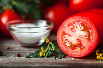 Red, ripe tomatoes on a dark background. Fresh tomatoes with herbs and spices