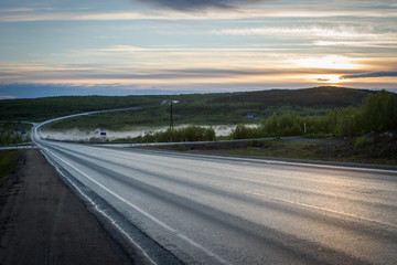 Asphalt road with fog on sunset.