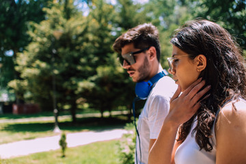 Naklejka premium Young couple in love walking together on a path in summer park