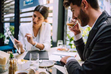 Small group of co-workers discussing project in cafe