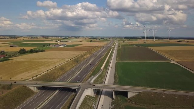 Aerial view of Highway A8 and wind turbines in corn fields on the swabian alp between Ulm and Merklingen with construction works of the Stuttgart21 railway project