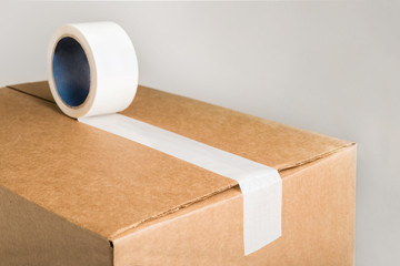Close-up of corrugared brown cardboard box with white adhesive tape