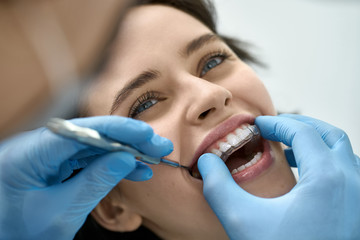 Pretty woman's teeth treatment in dental clinic