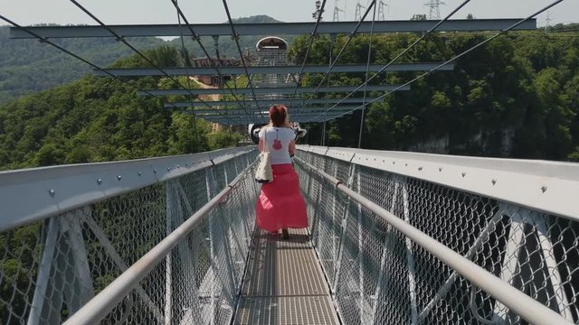 Sochi, Russia - may 2019. People walk on bridge in Sochi Skypark AJ Hackett. Back follow shot. SkyBridge in Sochi.