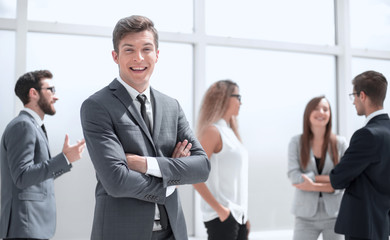 smiling young businessman standing in office.