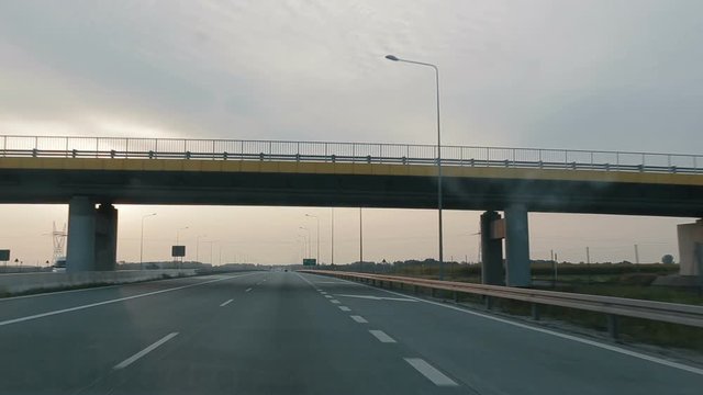 POV driving along a wide empty morning road early in the morning during sunrise.. Point of view driving, view from inside the car on on the autobahn in Poland.