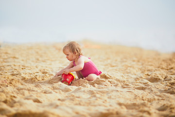 girl playing with sand on the beach