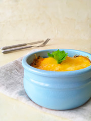 bowl of soup. Julien, prepared in a round blue ceramic form, decorated with greenery. Casserole in individual forms on a light background.