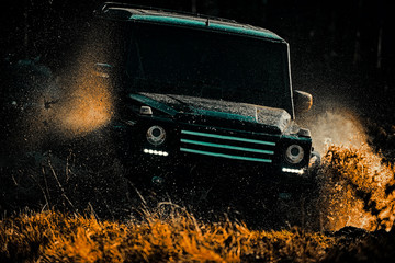 Off-road vehicle goes on the mountain. Drag racing car burns rubber. Extreme. Off-road car. Mud and water splash in off-road racing. Best Off Road Vehicles. © Volodymyr