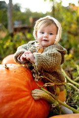 laughing adorable baby girl with a pumpkin