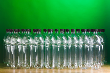 Naklejka na ściany i meble empty plastic bottles on green background