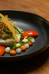 barramundi filet on basil sauce served with white rice and vegetable. Exquisite dish. Creative restaurant meal concept.	