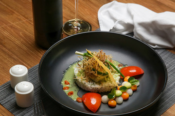 barramundi filet on basil sauce served with white rice and vegetable. Exquisite dish. Creative restaurant meal concept.	