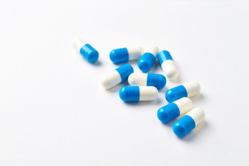 Tri-Creatine Malate capsules. Bodybuilding food supplements on white paper background. Close up. Copy space. 