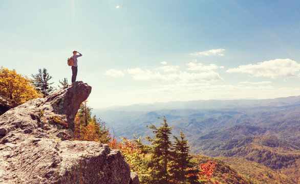 Man at the edge of a cliff overlooking the mountains below