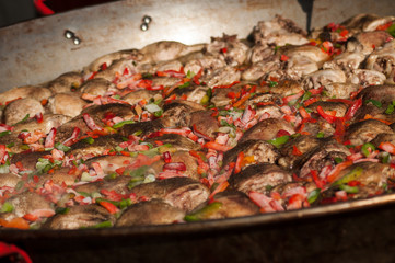 Closeup of chicken and peppers in a big stove in outdoor