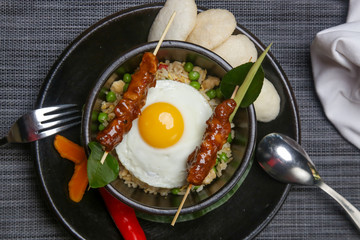 Nasi goreng - fried rice with chicken satay and a fried egg. Exquisite dish. Creative restaurant meal concept.