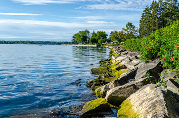 Fototapeta na wymiar Rock lined coastline on the shore of Brockville, Ontario on the St. Lawrence River