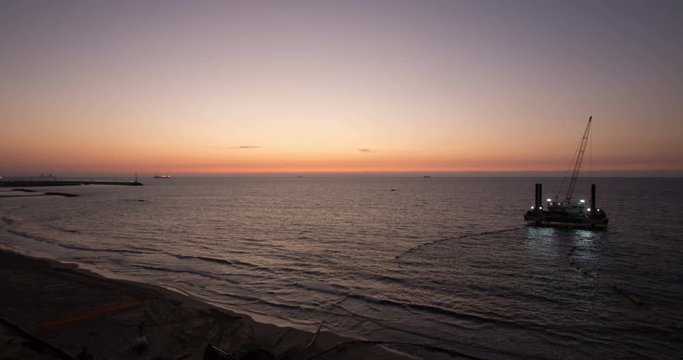 Time laps of the beach of Ashkelon Israel, at sunset, drilling rig in the sea