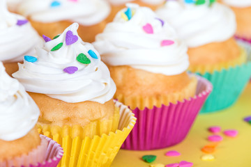 Colorful cupcakes decorated with heart shaped sprinkles