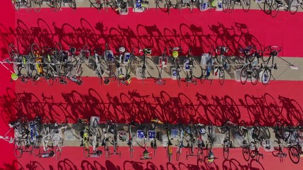 Aerial top down view road bicycles in transition zone triathlon. Shadows of bikes at red carpet
