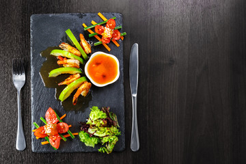 Obraz na płótnie Canvas Shrimp dish with apples, lettuce, tomatoes, herbs
