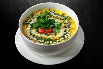 A plate of soup with tomatoes