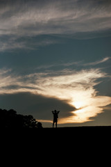 Silhouette of man with clouds in the background 