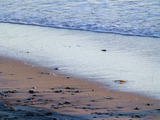 Rocks in sand at beach during sunset