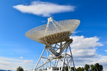 Array of satellite dishes or radio antennas against sky. Space o