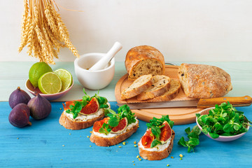 Toast from swiss twisted bread, with feta cheese or ricotta, fresh figs, rolled slice of bacon, fresh leaves of corn or valerian salad and crushed pistachio nuts. With touch of lime juice.
