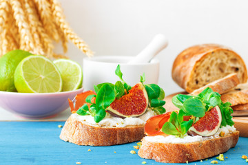 Toast from swiss twisted bread, with feta cheese or ricotta, fresh figs, rolled slice of bacon, fresh leaves of corn or valerian salad and crushed pistachio nuts. With touch of lime juice.