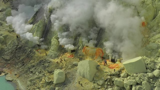Cinematic aerial view of sulfur mine spewing toxic sulfur gas clouds at the crater of Kawah Ijen volcano, East Java, Indonesia.