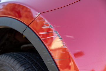 Closeup of deep scratches in red paint of car bumper - 290172630