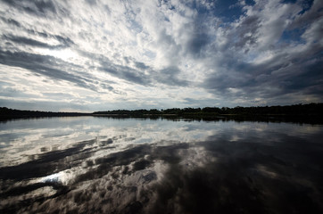 Fototapeta premium Rio Inirida en Guainia Colombia, reflejos en el agua, atardeceres en el rio y espejos de agua