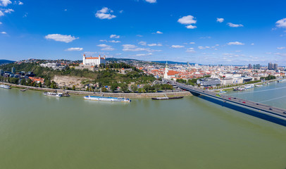 Fototapeta premium Aerial view of Bratislava (Pozsony, Pressburg) on a sunny afternoon with the castle on the hilltop, saint martin church old town and bridge