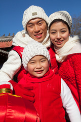 Family holding lantern dressed in holiday attire