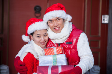 Couple holding gifts dressed in holiday attire