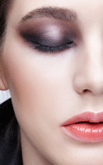 Closeup macro portrait of female face.  Girl with perfect skin and violet - black smoky eyes make-up.