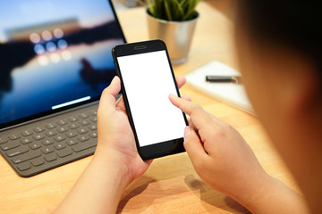 Cropped shot view of man hands holding smart phone with blank copy space screen for your text message or information content, female reading text message on cell telephone during in urban setting. 