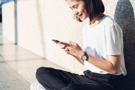Asian women of happy smiling sitting using smartphone.The concept of using the phone is essential in everyday life.